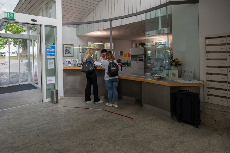 Angehörige und Mitarbeiterin am Empfang in der Rehaklinik Tschugg